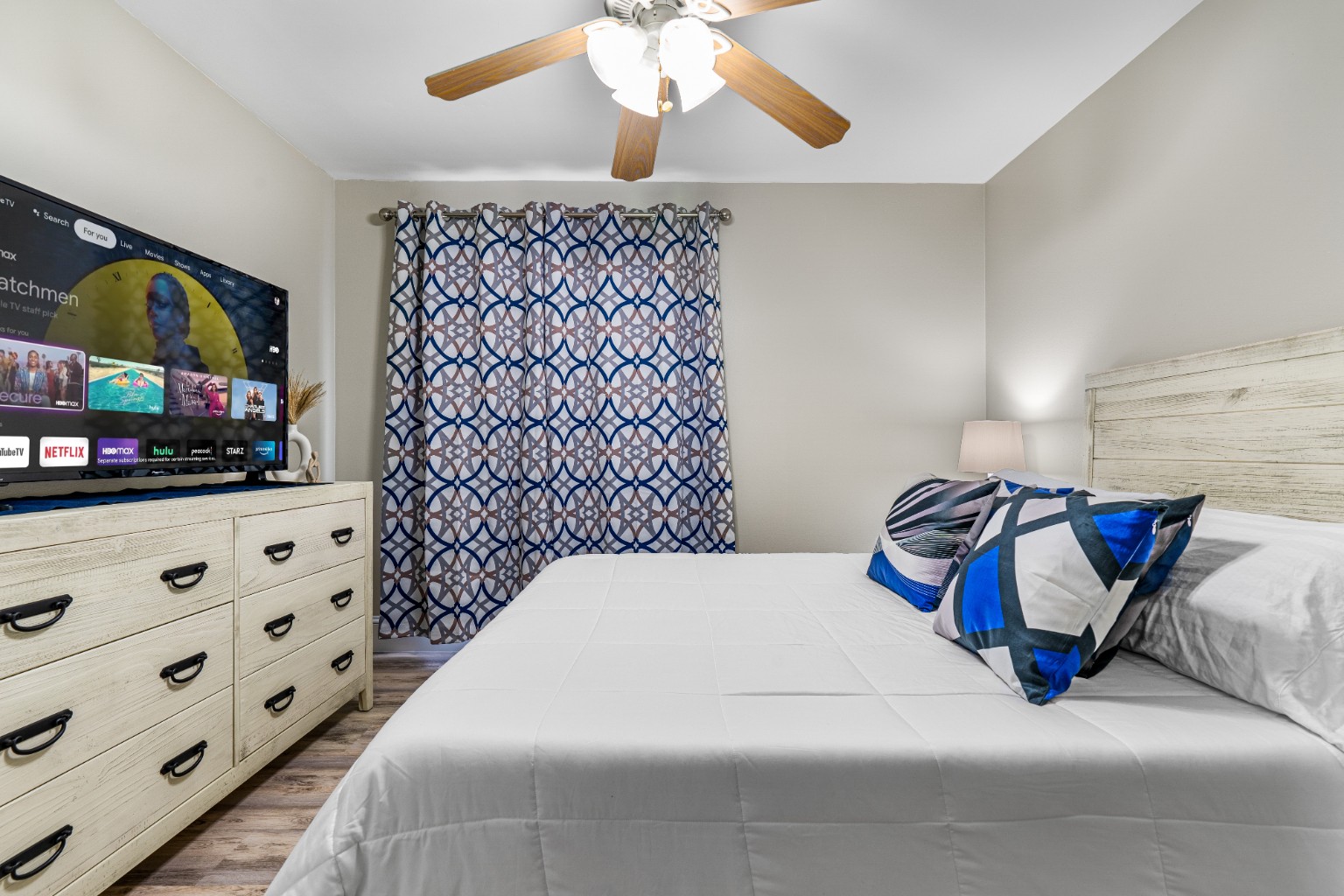 Bedroom with television and patterned curtains